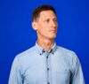 Christoph Bohlender, Mitgründer und Geschäftsführer der MENSCH Kreativagentur, vor blauem Hintergrund.