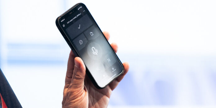 Sparcherkennungssoftware, KI-driven, von Nuance und microsoft auf dem Smartphone, gehalten von einer männlichen Hand.